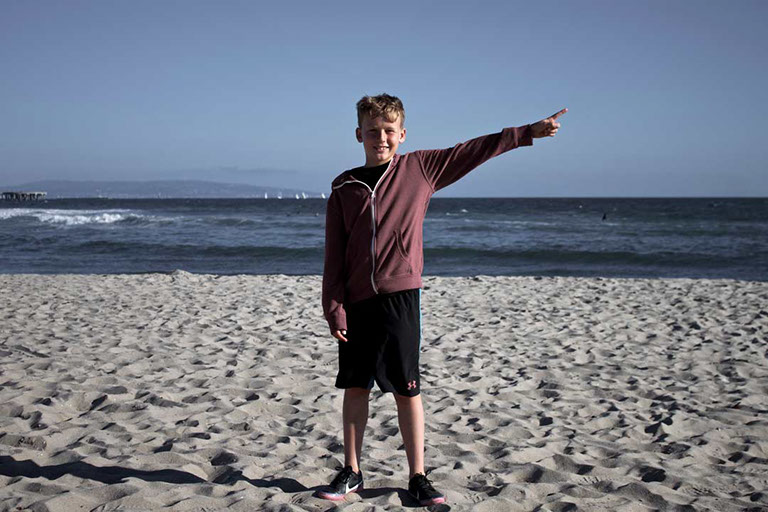 Félix Ossa - Dónde está Colombia? - Imagen de un niño en la playa apuntando su mano hacia la derecha