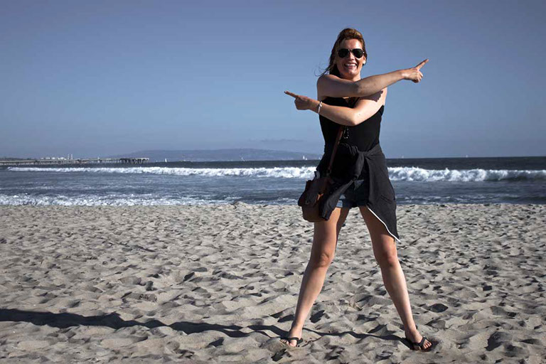 Félix Ossa - Dónde está Colombia? - Imagen de una mujer en la playa. Sus manos están apuntando en varias direcciones